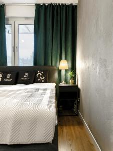1 dormitorio con 1 cama y cortina verde en Apartament Bóżnicza en Poznan