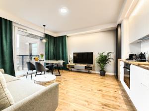 a living room with a couch and a table with chairs at Apartament Bóżnicza in Poznań