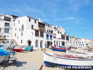 eine Gruppe von Booten am Strand vor einem Gebäude in der Unterkunft Apartament amb piscina i aparcament - Baixos amb jardinet in Calella de Palafrugell