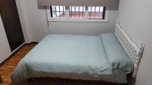 een klein bed in een kamer met een raam bij Centro de Gijón a seis minutos de la playa in Gijón