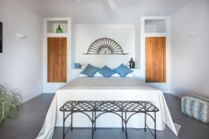 1 dormitorio con 1 cama grande con almohadas azules en Salina Case Vacanza, en Malfa