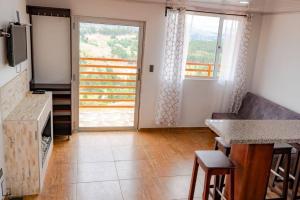 a living room with a kitchen and a large window at Chalet Familiar Full equipado! Jacuzzi privado 30 minutos gratis! in Sogamoso
