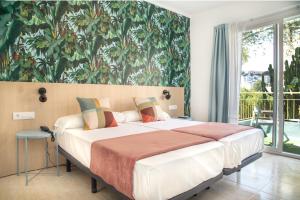 sypialnia z dużym łóżkiem z obrazem na ścianie w obiekcie 4U Miranda - Adults Only w miejscowości Santa Ponsa