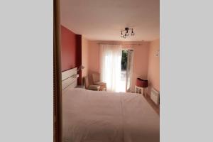 1 dormitorio con cama blanca y ventana en Gîte provençal indépendant avec piscine chauffée : LE SUY BIEN, en Flayosc