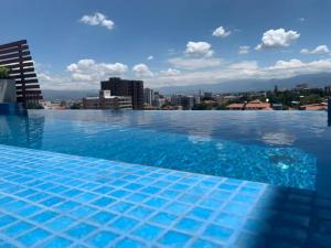 a large swimming pool with a city in the background at Depto de lujo en Smart Design in Cochabamba