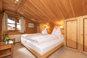 een slaapkamer met een groot bed in een houten kamer bij Chalet Innerhof in Alpbach