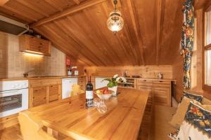 a kitchen with a wooden table with a bottle of wine at Chalet Innerhof in Alpbach