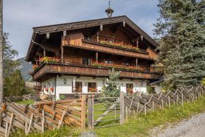 a large wooden house with flowers in front of it at Chalet Innerhof in Alpbach