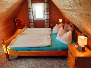 ein Schlafzimmer mit einem Bett in einem Blockhaus in der Unterkunft Moritz - Ferienhaus östlich der Dorfstraße in Grieben Insel Hiddensee in Grieben