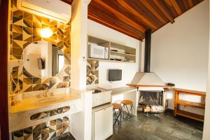 a kitchen with a sink and a fireplace at Pousada Il Villaggio in Santo Antônio do Pinhal