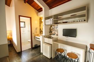 a kitchen with a sink and two stools in a room at Pousada Il Villaggio in Santo Antônio do Pinhal