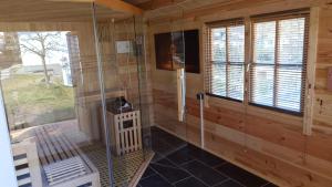 a sauna with a shower in a wooden cabin at Ferienwohnung Walfisch inkl Strandkorb in Göhren +44 photos