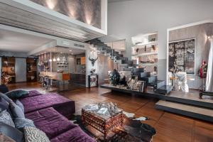 a living room with a purple couch and stairs at CasaDodici in Cesenatico