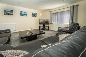 a living room with a couch and a table at Grange Cottage, Nr Cartmel Racecourse in Flookburgh