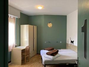 two beds in a room with green walls at Route77 hostel in Toscolano Maderno