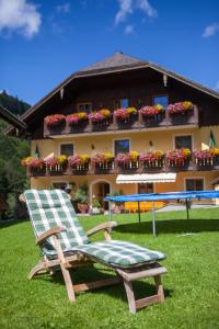 a chair and a table in front of a house at Bio-Bauernhof Vordergrubenbach - Familie Oberascher in Hintersee