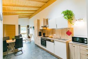 a kitchen with white cabinets and a table with a sink at Naglerhof in Curon Venosta