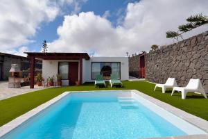 una piscina en un patio con sillas y una casa en Villa Nelida peace lovers Vegueta By PVL, en La Vegueta