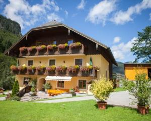 a large house with flower boxes on the side of it at Bio-Bauernhof Vordergrubenbach - Familie Oberascher in Hintersee