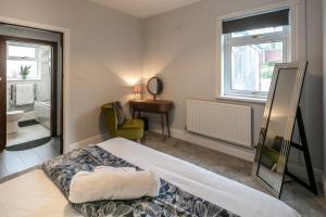 een slaapkamer met een bed, een bureau en een raam bij Blue Rose Cottage in Burry Port