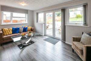 een woonkamer met een bank en een tafel bij Blue Rose Cottage in Burry Port +12 foto's