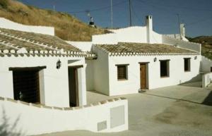a white building with doors and a roof at Casas Cueva el Mirador de Orce in Orce