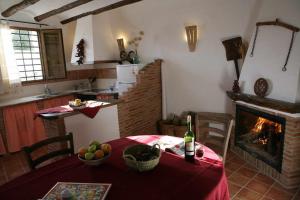 a kitchen with a table with a bottle of wine and a fireplace at Casas Cueva el Mirador de Orce in Orce