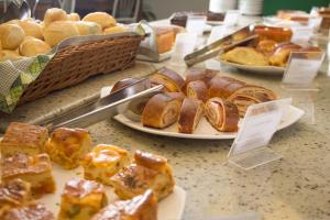 a table with plates of pastries and other pastries at Tower Franca Hotel in Franca