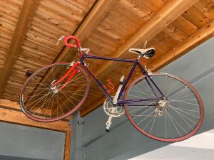 a bike hanging from the ceiling of a building at Route77 hostel in Toscolano Maderno