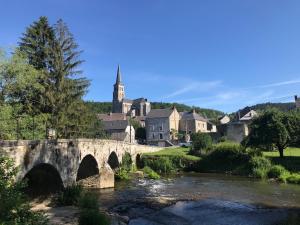 a bridge over a river in a town with a church at Chez Marie-Angèle in Treignes