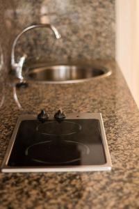 a kitchen counter with a sink with a ipod on it at Apartamentos La Torreta in Altafulla