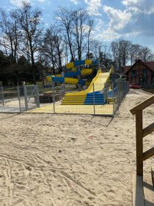 un parque infantil con un tobogán en la arena en Dom nad jeziorem Charzykowy en Charzykowy