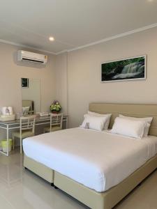 a bedroom with a large bed and a desk at Siri Ville Hotel in Si Sa Ket
