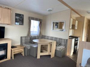 a small living room with a table and a couch at 3 bedroom 8 berth standard caravans with Hot Tub,Mountain Bikes in Tattershall