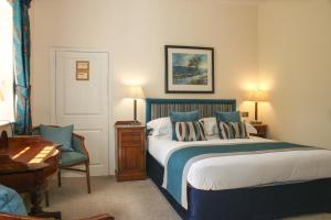 a bedroom with a bed and a desk at Rollestone Manor B&B and Restaurant in Shrewton