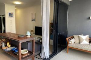 uma sala de estar com uma secretária e um sofá em DELUXE CLOSE TO CITY WIFI NETFLIX WINE PARKING em Perth