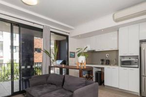 a living room with a couch and a kitchen at DELUXE CLOSE TO CITY WIFI NETFLIX WINE PARKING in Perth