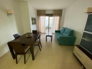 a living room with a table and a blue couch at Apartamentos Entreplayas Altamar in Alcossebre