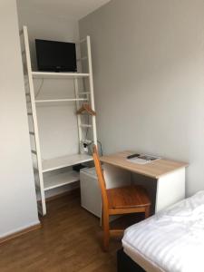 a bedroom with a desk with a computer and a bed at Hotel Schwaferts in Wuppertal