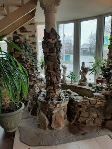 a stone fireplace in a room with plants and windows at Gostevoi Dom Nadezda in Taganrog