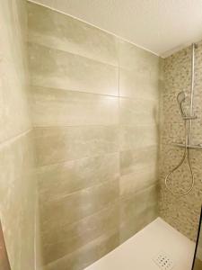 y baño con ducha y pared de color beige. en Kyriad Direct Chalon Sur Saone Nord, en Champforgeuil