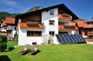 una casa con un pannello solare in giardino di Wohlfühl-Ferienwohnungen Schneider a Bad Hindelang