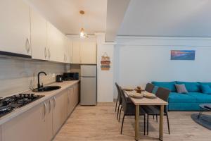 a kitchen and living room with a table and a blue couch at Moonlight Bliss Apartment in Mamaia