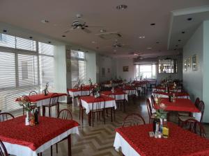 un restaurante con mesas y sillas rojas y blancas en Hotel Derby en Cattolica