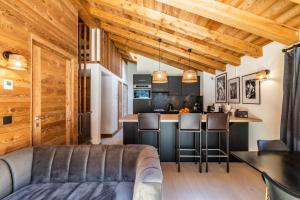 Una sala de estar con un sofá y una cocina. en Sapelli apartment Argentière Chamonix - by EMERALD STAY, en Chamonix-Mont-Blanc