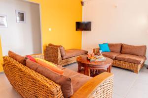 a living room with a couch and a table at Villa Arc-en-ciel in Le Moule