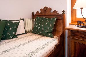 a bed with green and white pillows on it at Wohlfühl-Ferienwohnungen Schneider in Bad Hindelang