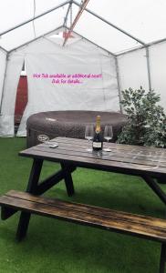 a picnic table with a bottle of wine and two glasses at The Baltic Townhouses by Serviced Living Liverpool in Liverpool