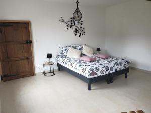 Un dormitorio con una cama con almohadas rosas. en La Clef des Champs, en Potelle