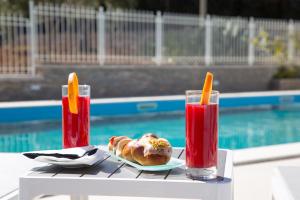 a table with a plate of food and two drinks at Principe Alogna Hotel & SPA in Altavilla Milicia